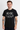 Man wearing a black AC/DC t-shirt with white text on a white background