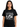 Woman wearing Genesis Lamb Lies Down Tour T-Shirt featuring artistic design from the 1974 North American Tour.